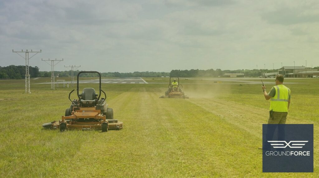 Commercial mowing crew performing airside vegetation management along a runway safety area at a Georgia airport.